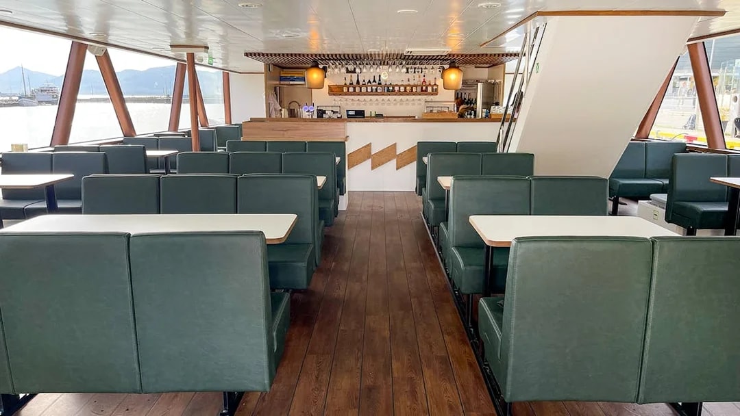 Interior of a boat with seating and bar area for Tromso silent whale watching tour.