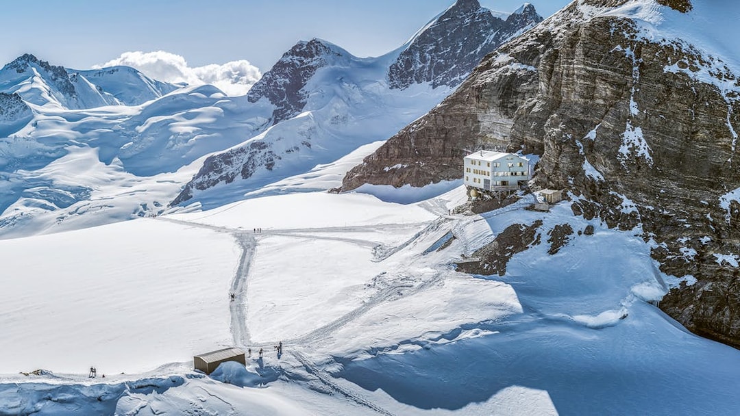 Jungfraujoch snowy landscape with mountain peaks and a building, seen on a day trip from Zürich.