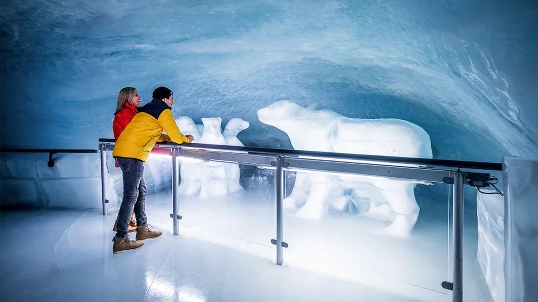 People viewing polar bear ice sculptures in the Ice Palace at Jungfraujoch.