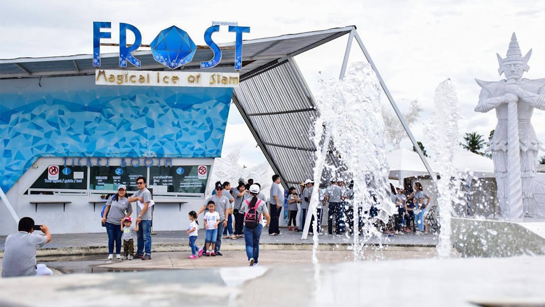 Visitors at Frost Magical Ice of Siam entrance with fountain and statue in Pattaya, Thailand.