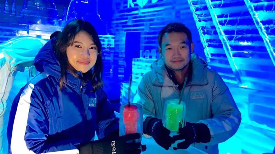 Visitors enjoying drinks at Frost Magical Ice of Siam, surrounded by ice sculptures.