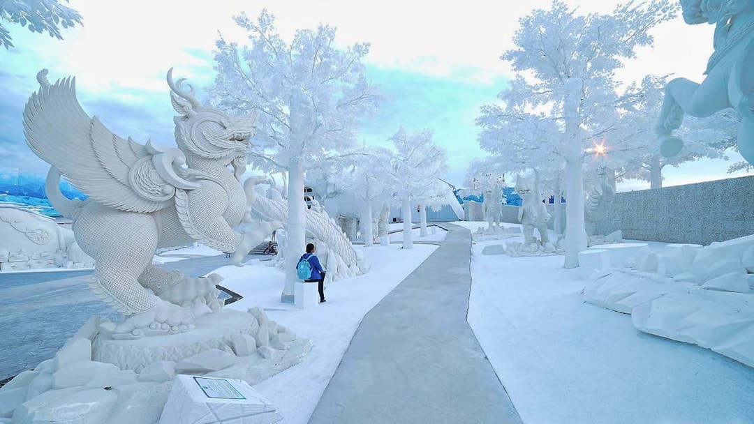 Pathway through ice sculptures at Frost Magical Ice of Siam, featuring mythical creatures.