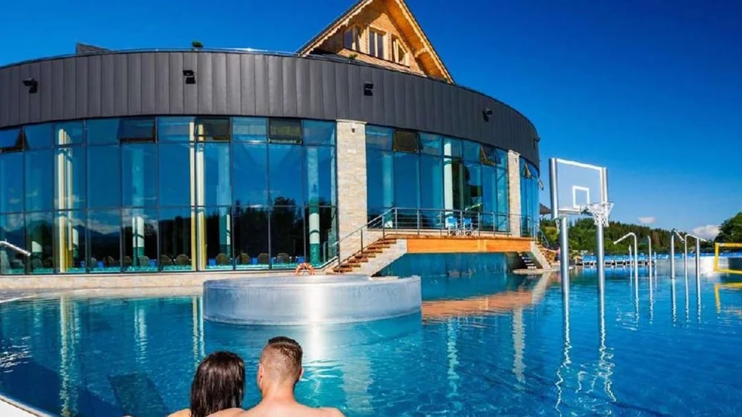 Couple relaxing in outdoor pool at Chocholow Thermal Baths, Poland.