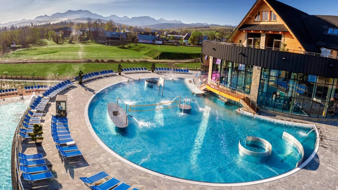 Outdoor pool area at Chocholow Thermal Baths with mountain views in the background.