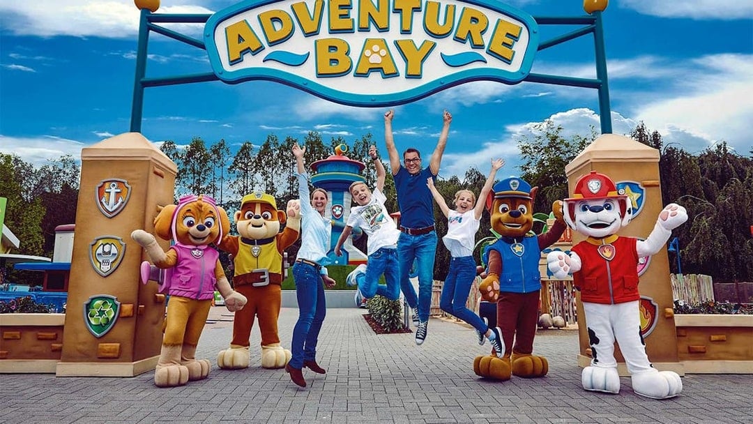 Visitors jumping with joy at Adventure Bay entrance, Bottrop Movie Park, Germany.