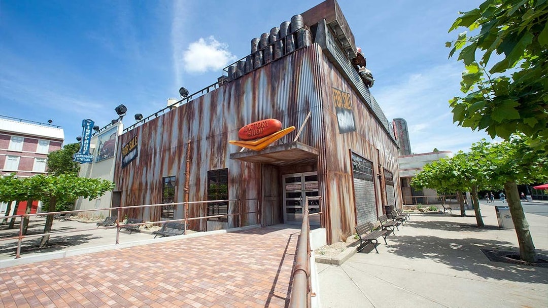 Van Helsing's Factory entrance at Movie Park with industrial facade and trees nearby.