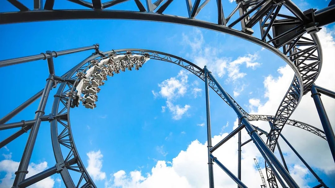 Roller coaster loop at Movie Park Germany against blue sky.