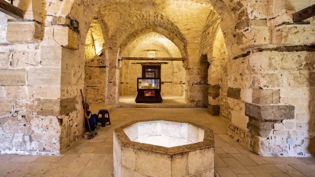 Underground chamber in Alexandria with stone walls and an octagonal well.