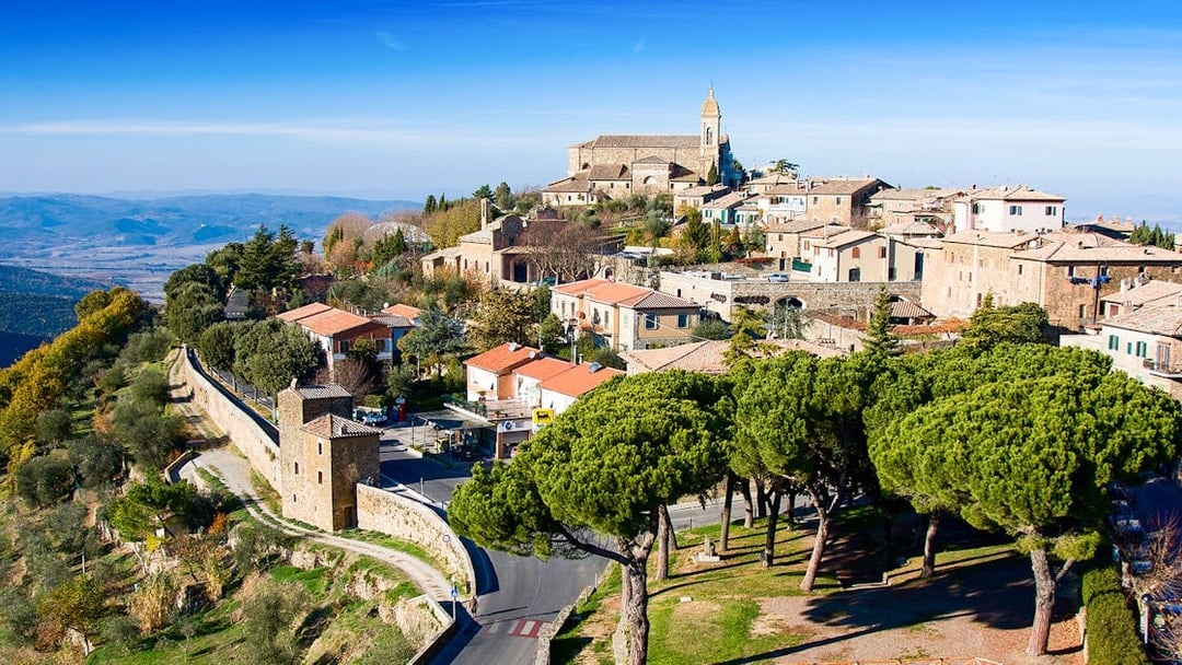 Hilltop view of Montalcino, Italy, featuring historic buildings and scenic landscape.