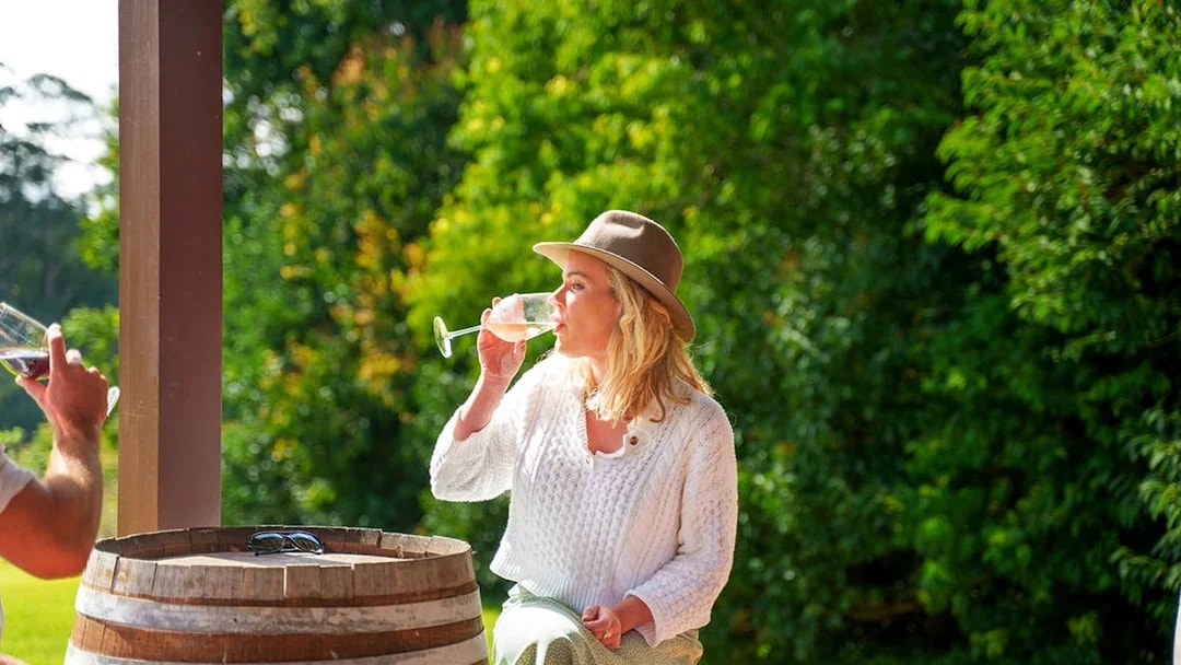 Woman enjoying wine at a vineyard during a full day winery tour near Brisbane.
