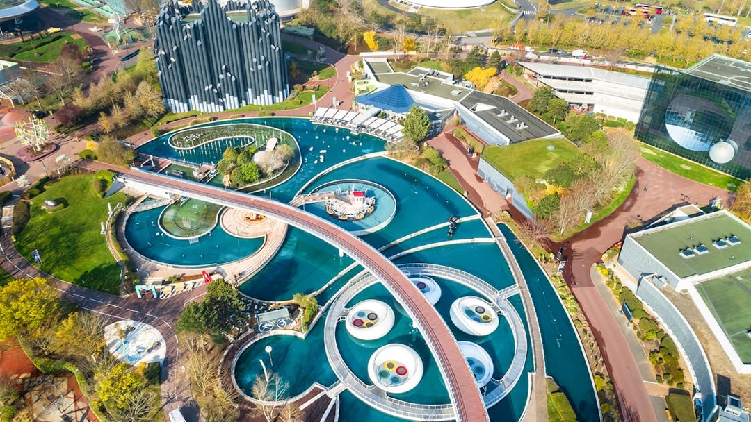 Aerial view of Futuroscope theme park with futuristic architecture and water features in Poitiers, France.