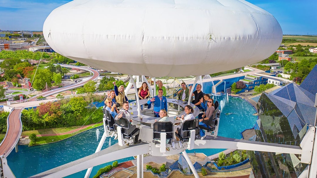Visitors enjoying the Aerobar at Futuroscope, France, with panoramic park views.