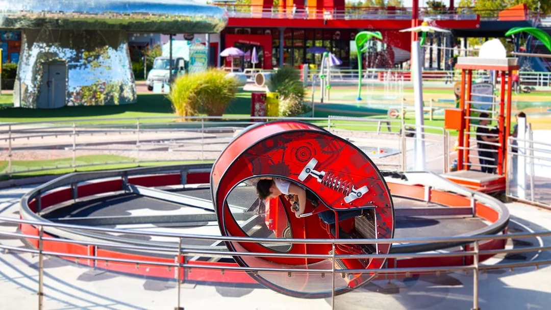 Centrifuge ride at Futuroscope theme park with a person inside the rotating capsule.