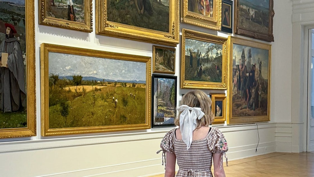Visitor admiring paintings inside Galleria Arte Moderna Nazionale, Rome.