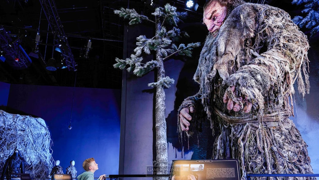 Giant figure display at Game of Thrones Studio Tour with visitor observing.