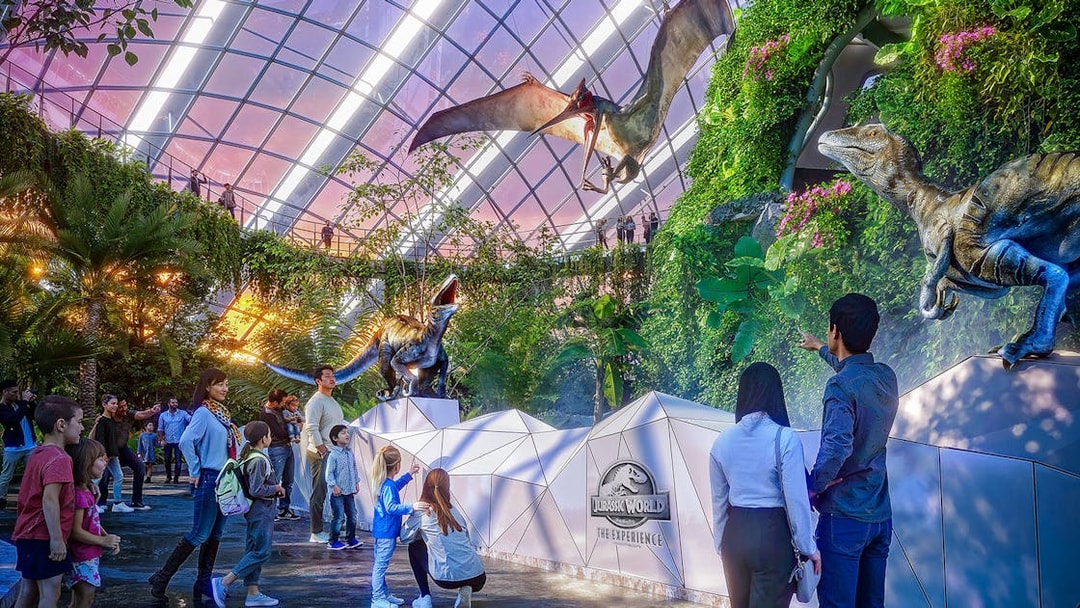 Visitors observing a pteranodon display at Jurassic World attraction.