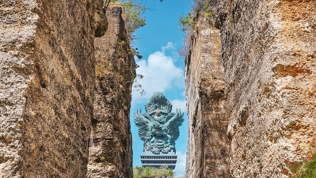 Garuda Wisnu statue framed by rocky cliffs in Bali, Indonesia.