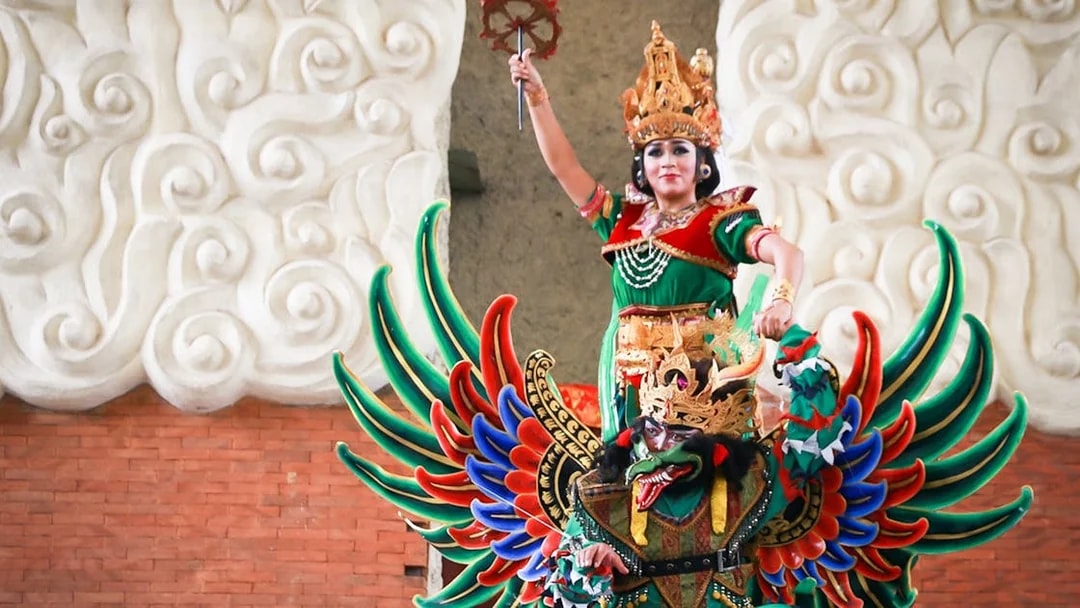 Traditional Balinese performer in colorful costume at Garuda Wisnu Kencana Culture Park, Bali.