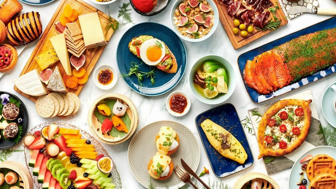 Assorted dishes at Gastronomy Buffet Dinner Experience, Dubai, featuring cheeses, fruits, and smoked salmon.