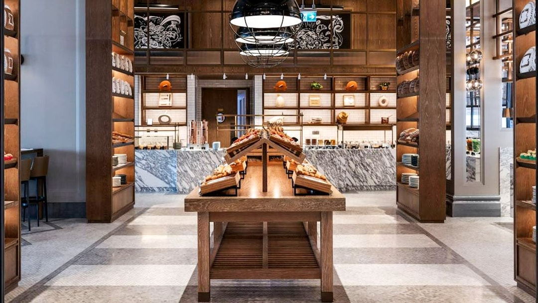 Dining area with wooden tables and shelves at Gastronomy, Dubai.