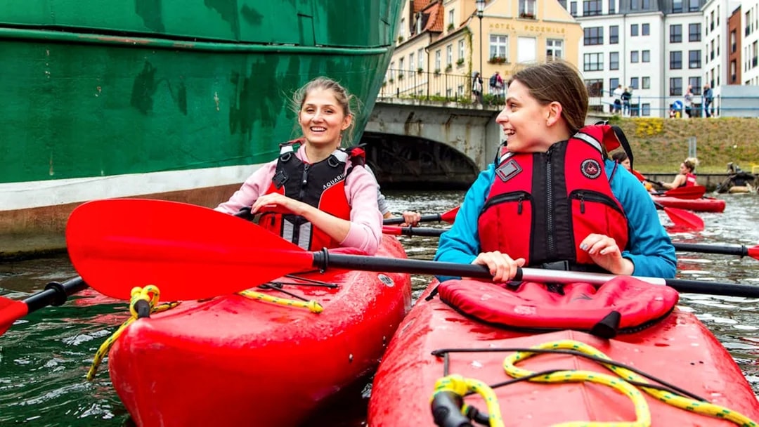 Kayakers paddling near historic buildings in Gdansk.