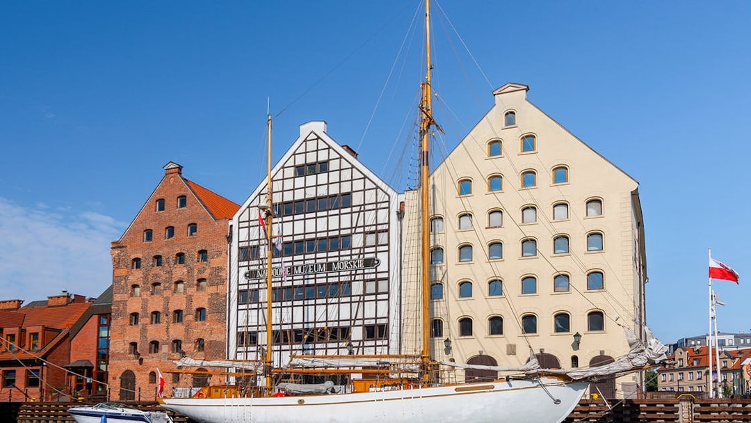 Gdansk Maritime Museum with sailboat on Motlawa River.
