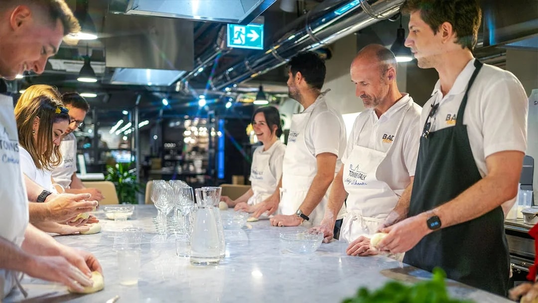 Participants kneading dough during a gelato and pizza making class in Milan.