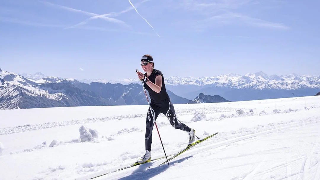 Cross-country skier on Glacier 3000 with Swiss Alps backdrop, near Montreux.