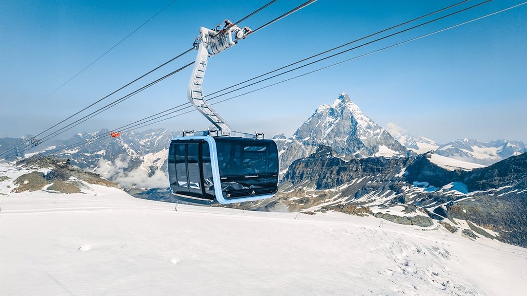 Cable car ascending Matterhorn Glacier Paradise with snowy mountain backdrop.