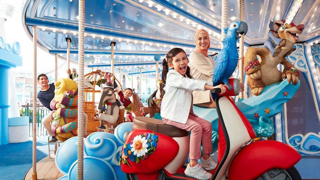 Visitors enjoying a colorful carousel ride at Genting SkyWorld Outdoor Theme Park.