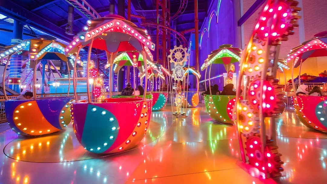 Colorful rides at Genting Skytropolis Indoor Theme Park, Malaysia, with vibrant lights and gears.