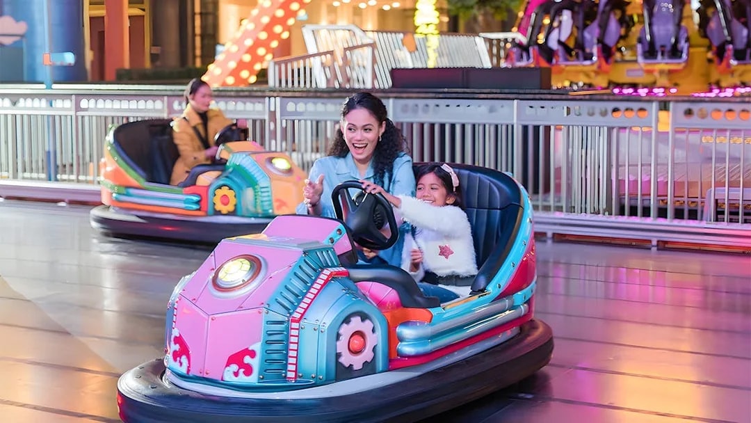 Family enjoying bumper cars at Genting Skytropolis Indoor Theme Park.