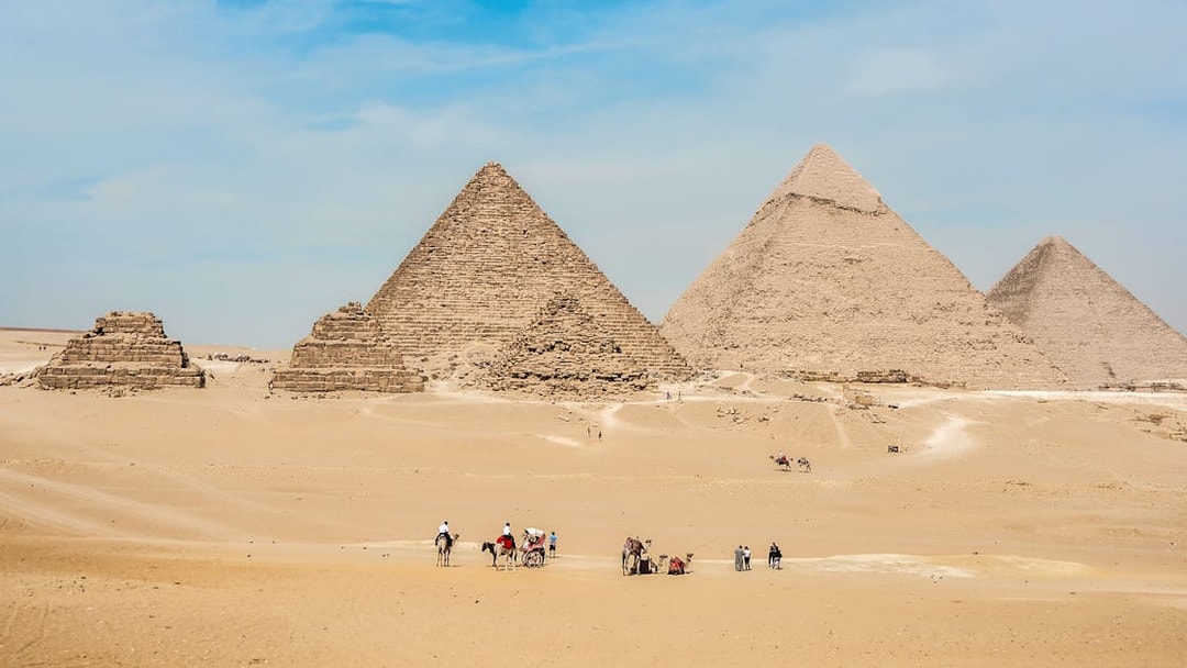 Giza Pyramids with tourists on camels, part of the Giza, Saqqara, Dahshur tour from Cairo.