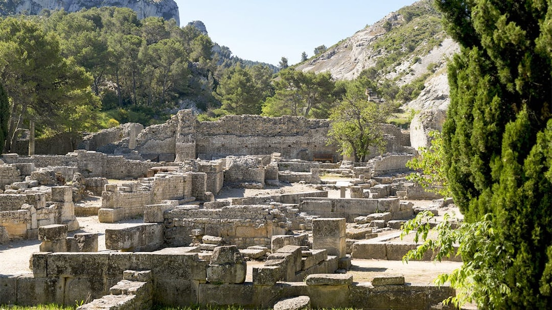 Glanum Archaeological Site ruins with stone structures and surrounding greenery in Saint-Rémy-de-Provence.