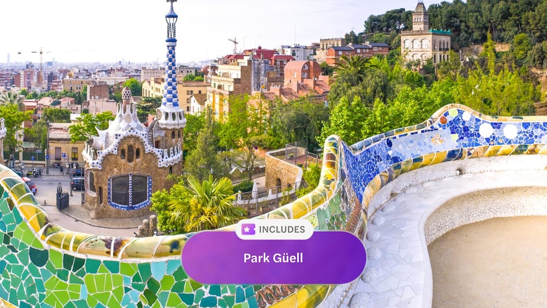 Park Güell's colorful mosaic terrace overlooking Barcelona cityscape.