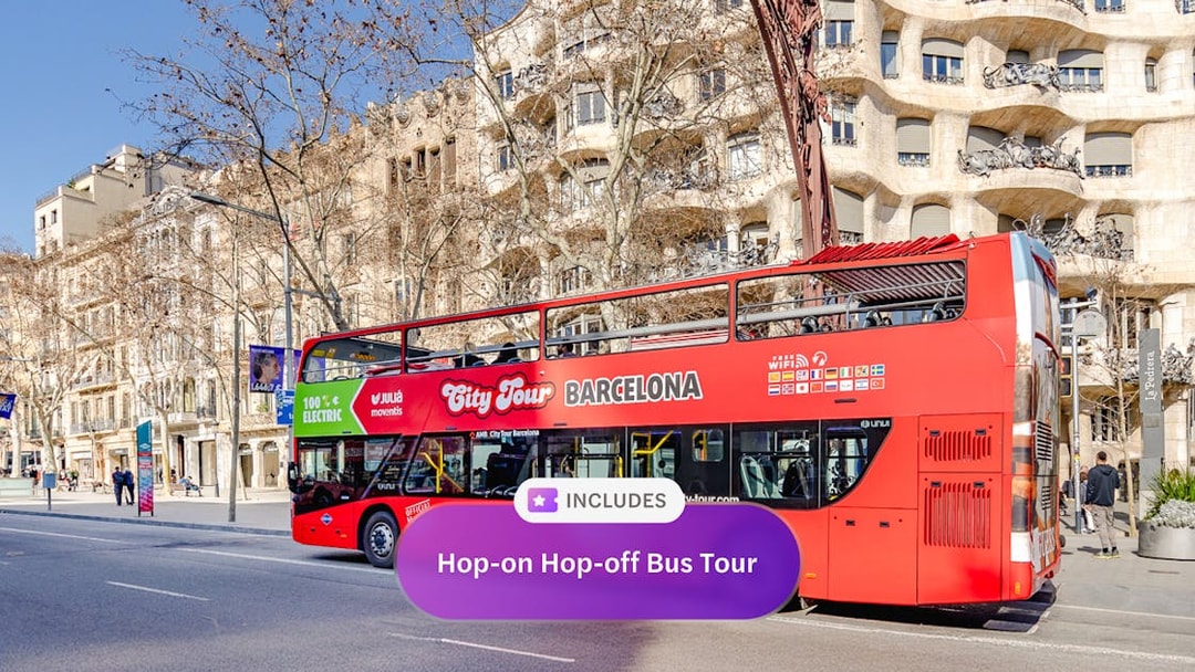 Red double-decker bus on a hop-on hop-off tour in front of Casa Milà, Barcelona.