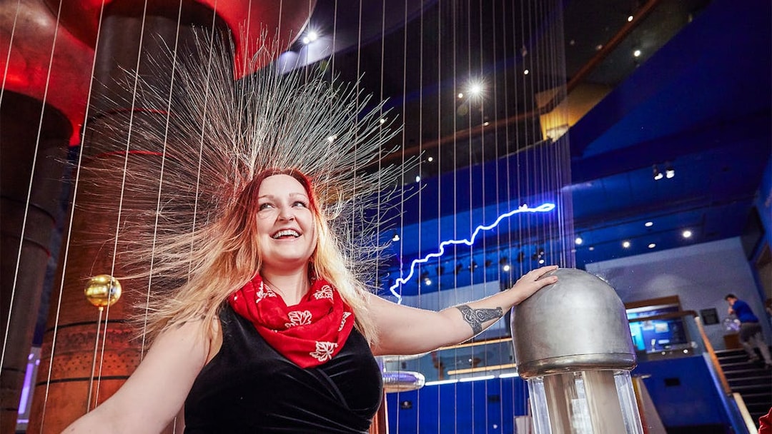 Visitor experiencing static electricity at Museum of Science Theater of Electricity.