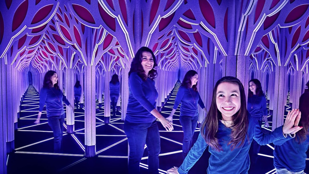 Visitors exploring a mirror maze in Chicago with the All-Inclusive City Pass.