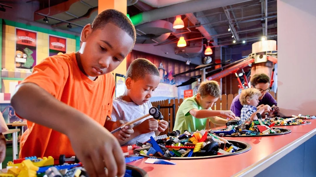 Children building with LEGO bricks at a Chicago attraction.
