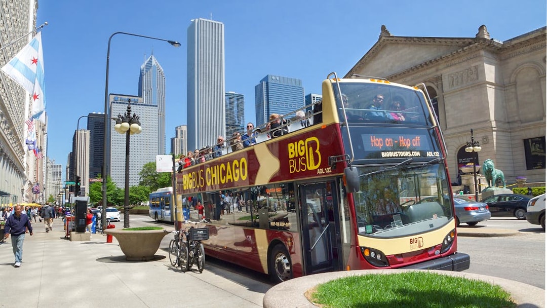 Big Bus Chicago tour passing by the Art Institute with city skyline in the background.