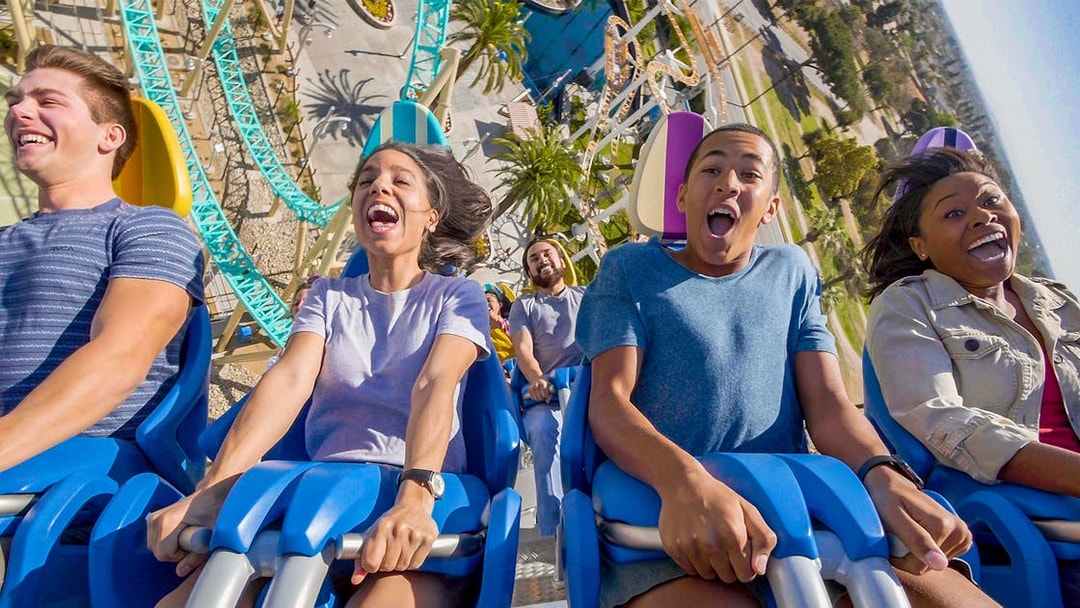 People enjoying a roller coaster ride at an amusement park in Los Angeles.