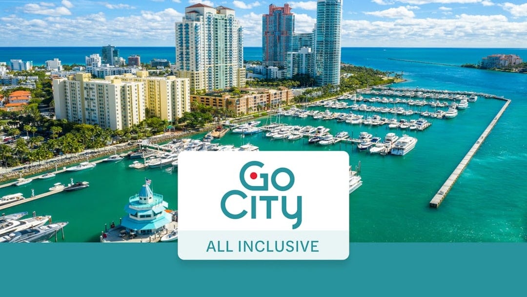 Drone view of Miami Beach marina with yachts and high-rise buildings.