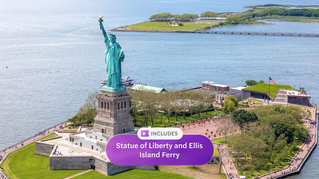 Statue of Liberty on Liberty Island with Ellis Island ferry in New York Harbor.