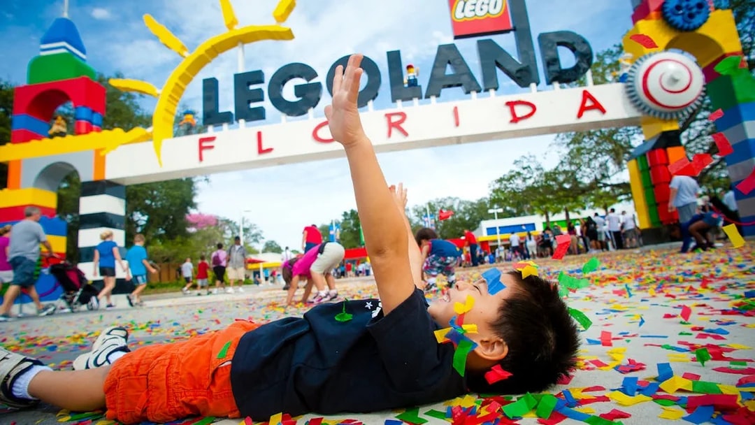 Child playing with confetti at LEGOLAND Florida entrance, Orlando Explorer City Pass.