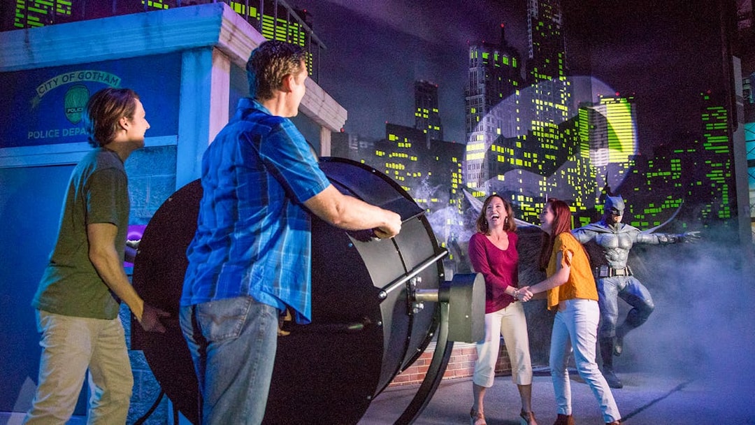 People interacting with a Bat-Signal exhibit at Madame Tussauds Orlando, included in the Orlando Explorer Pass.