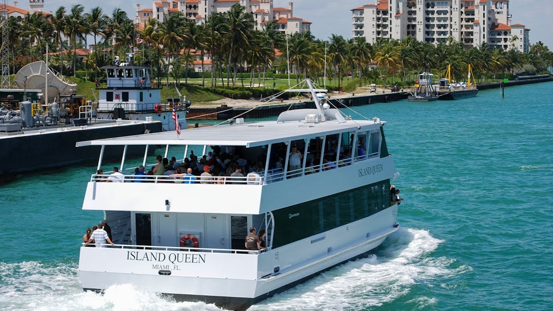 Tour boat cruising near waterfront buildings in Orlando, part of the Explorer City Pass experience.