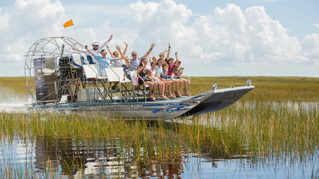 Airboat tour with passengers in Orlando wetlands, part of the Explorer City Pass experience.