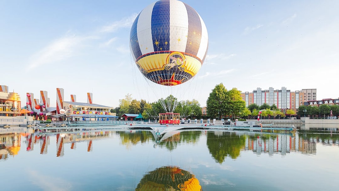 Ballon Panoramagique floating over a reflective lake at Disneyland Paris.