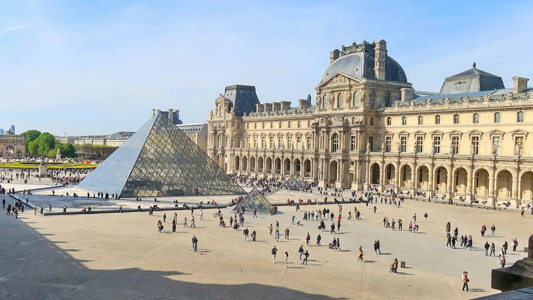 Louvre Museum courtyard with glass pyramid in Paris.