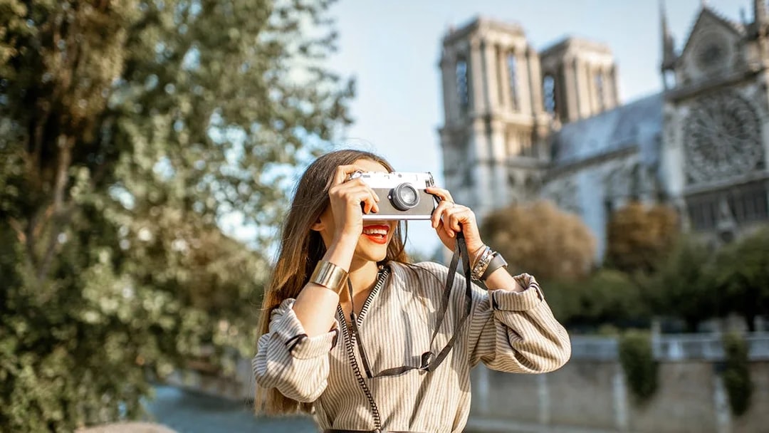 Tourist photographing Notre-Dame Cathedral in Paris.